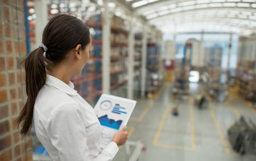 Business woman working on freight transportation and using a tablet computer to check stock at a warehouse; inventory management